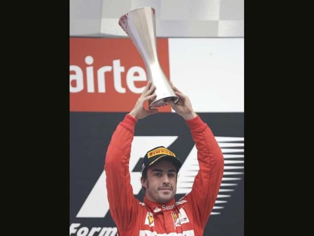 Ferrari driver Fernando Alonso of Spain holds his trophy aloft after his second place finish in the Indian Formula One Grand Prix at the Buddh International Circuit in Greater Noida. AP Photo