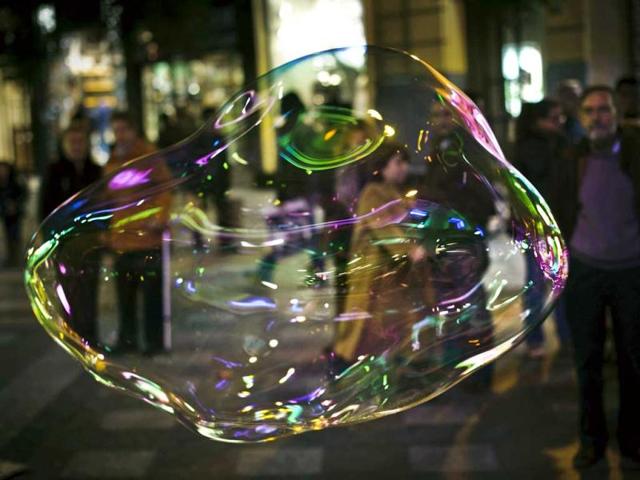 A soap bubble made by a man who performs for money in the street floats in Madrid. One Spaniard in four is now unemployed as the economic crisis tightens its grip. (AP Photo)