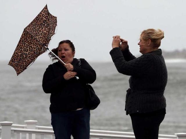 Lisa Cellucci (L), holds her umbrella as it is blown backwards from Hurricane Sandy's winds, as her friend Kim Vo (R) watches in Cape May, New Jersey. AFP Photo/Mark Wilson