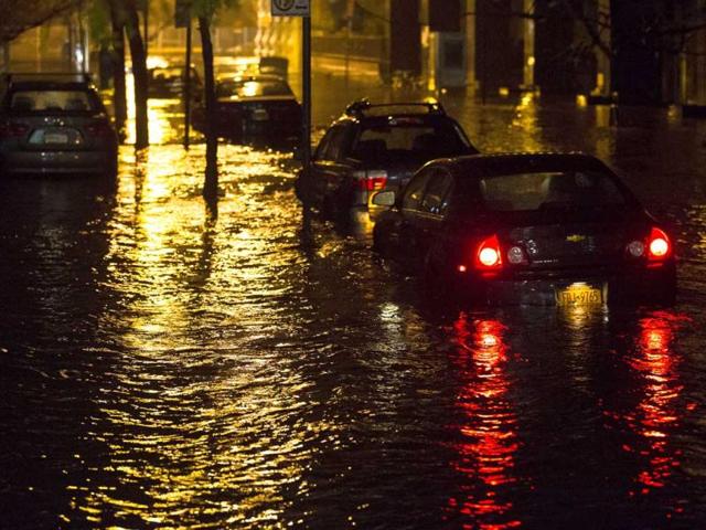 Vehicles are submerged during a storm surge near the Brooklyn Battery Tunnel in New York. Superstorm Sandy zeroed in on New York's waterfront with fierce rain and winds that shuttered most of the nation's largest city, darkened the financial district and left a huge crane hanging off a luxury high-rise. AP photo