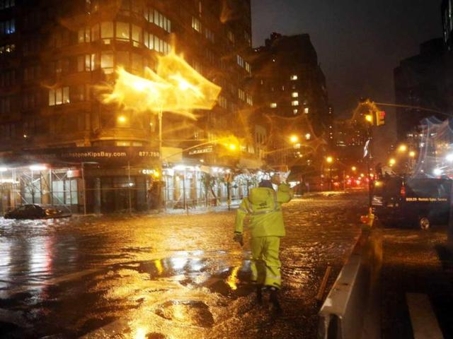 A Con Edison worker walks through the flood waters on the corner of 33th Street and 1st Street in front of NYU Langone Medical Center in Manhattan during rains from superstorm Sandy. AFP photo