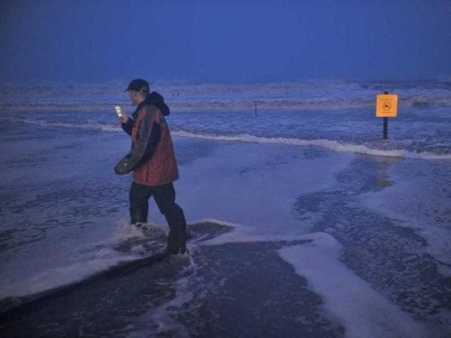 A man takes photographs as he walks through water on the beach near the time of high tide as superstorm Sandy approaches in Atlantic City, New Jersey. AFP photo
