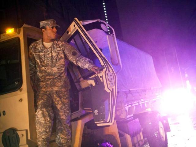 A soldier looks out from his personelle carrier during the landfall of superstorm Sandy, in the Financial District of New York. AFP photo