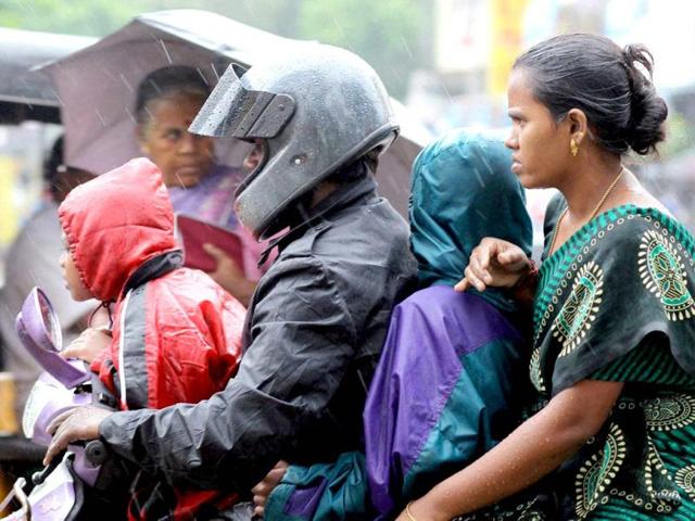 A family moves on a bike during rains in Chennai. PTI Photo