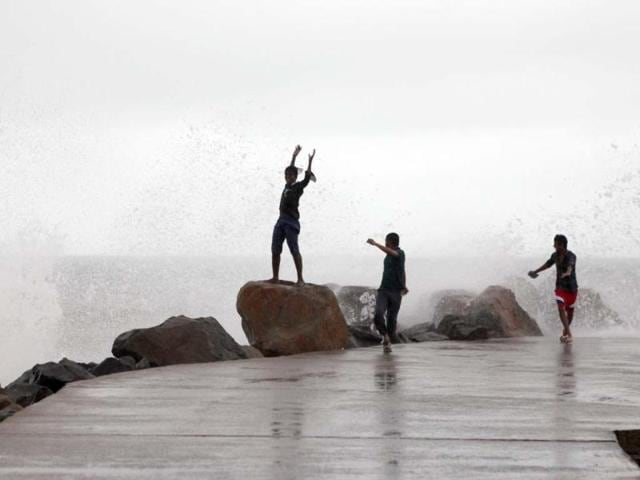 Youths gather as waves pound the waterfront at Kasimedu in Chennai. AFP Photo