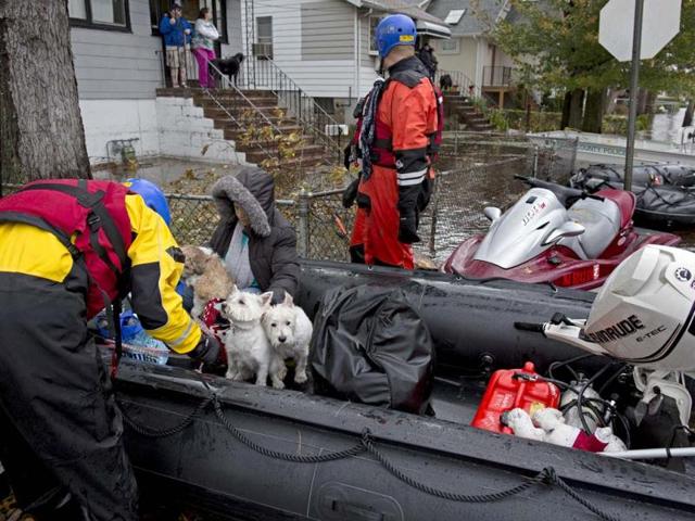 Esperanza Medina (L) is taken from a rescue boat along with pets in Little Ferry in the wake of superstorm Sandy, New Jersey. AP Photo