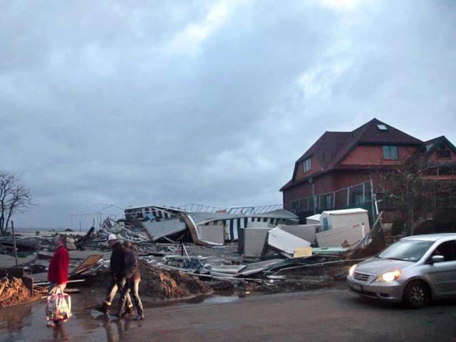 People walk through the houses destroyed in the aftermath from superstorm Sandy in Coney Island's Sea Gate community in New York. AP photo