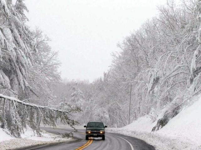 A vehicle drives past a fallen tree limb caused by heavy snow during a blizzard caused by superstorm Sandy in Garrett County, western Maryland. Reuters photo