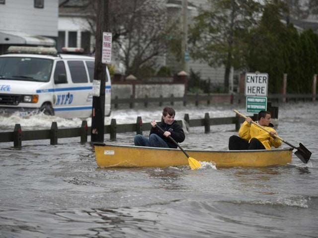 Residents use a canoe to paddle through flood waters left from superstorm Sandy at the Breezy Point section of the Queens borough in New York. Reuters photo