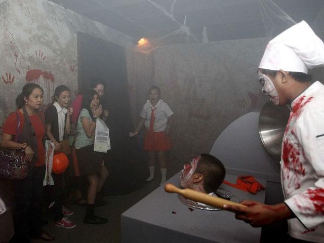 Actors dressed as zombies scare people entering a "haunted school" during a Halloween celebration at a mall in Manila. REUTERS/Cheryl Ravelo