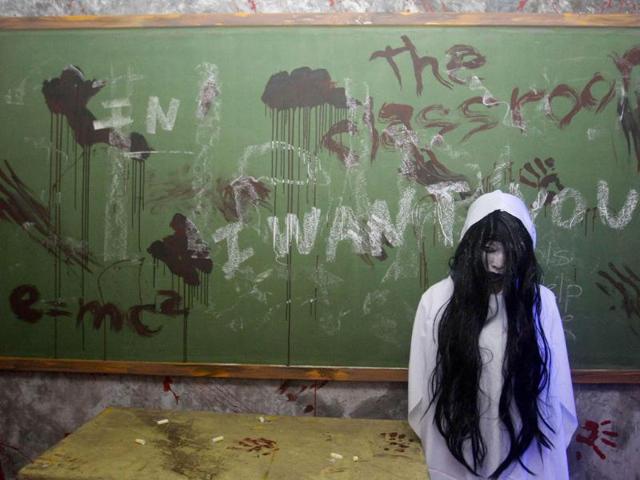 An actor dressed as a ghost scares people entering a "haunted school" during a Halloween celebration at a mall in Manila. REUTERS/Cheryl Ravelo