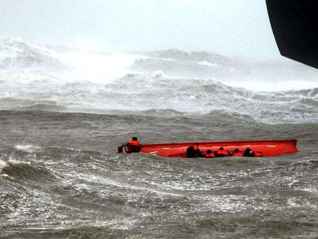 Members of Pratibha Cauvery struggling in mid-sea to hold on to a life boat, which got capsized due to rough sea caused by cyclone Nilam, near Elliotts Beach in Chennai. PTI Photo