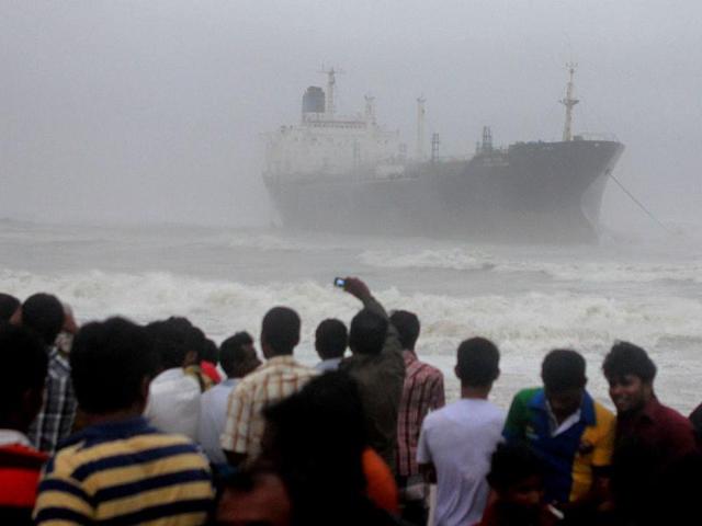 Onlookers gather on the beach after the oil tanker ship Pratibha Cauvery ran aground off the coast in Chennai. AFP Photo