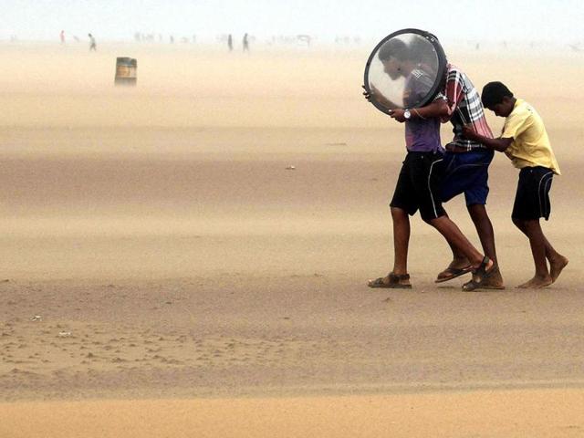 People save themselves at the Marina Beach following high speed wind due to cyclonic storm Nilam in Chennai. UNI Photo