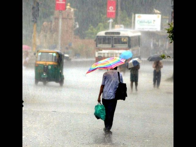 People walk during rain due to the effect of cyclone Nilam in Vijayawada district of Andhra Pradesh. PTI Photo