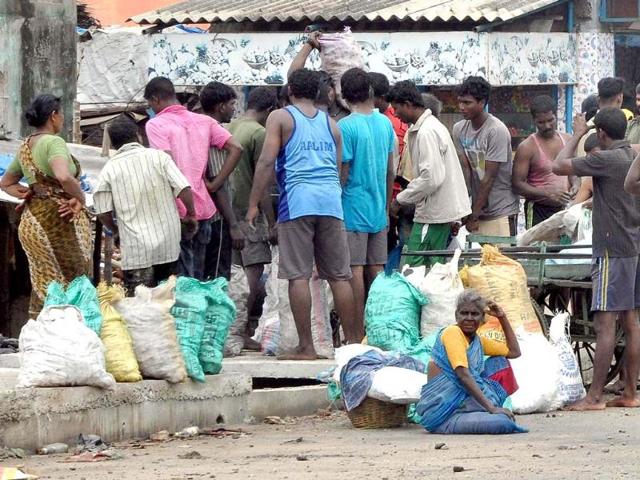 People after collecting the coal from the sea near Rayapuram fishing harbour. The coal was spread near Madras Port Trust during the off-loading from the ship washed ashore following cyclonic storm Nilam, in Chennai . Agencies