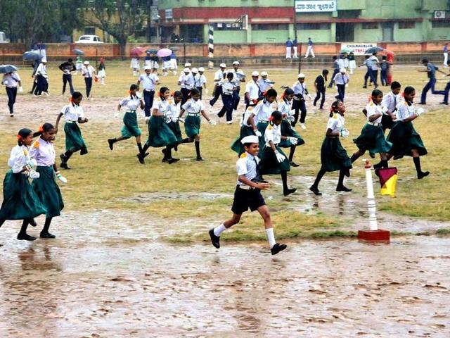 School children, dressed up for Kannada Rajyothsava cultural programmes, run away as the function was cancelled after rains due to Nilam cyclone in Chikmagalur in Karnataka . PTI Photo