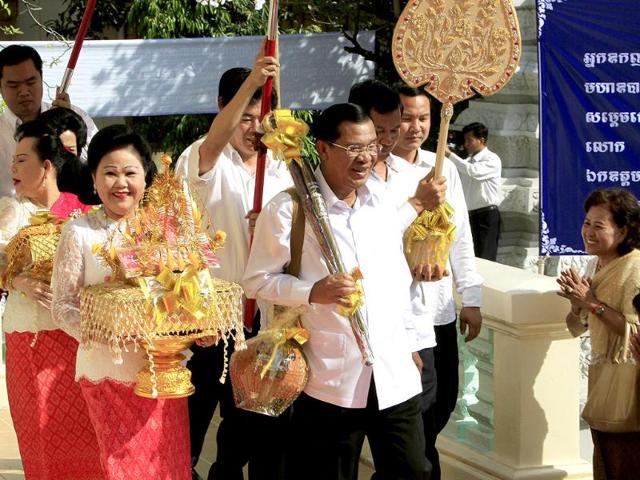 Cambodian Prime Minister Hun Sen walks together with his wife, Bun Rany, during a Buddhist ceremony called "Kathen Tean" at Botum Vodey pagoda in Phnom Penh, Cambodia. AP/Heng Sinith