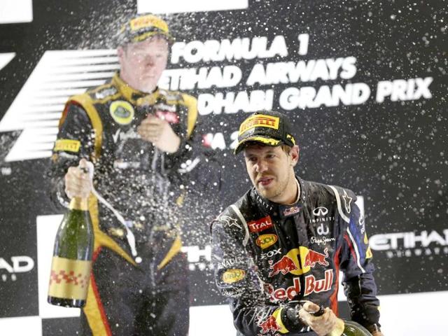 Third place Red Bull driver Sebastian Vettel of Germany sprays rose water as he celebrates on the podium during the Emirates Formula One Grand Prix, at the Yas Marina racetrack, in Abu Dhabi, United Arab Emirates. AP photo
