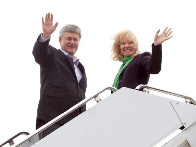 Canadian Prime Minister Stephen Harper and his wife Laureen wave while boarding their plane before departing for India to boost bilateral trade and economic ties, in Ottawa. Reuters