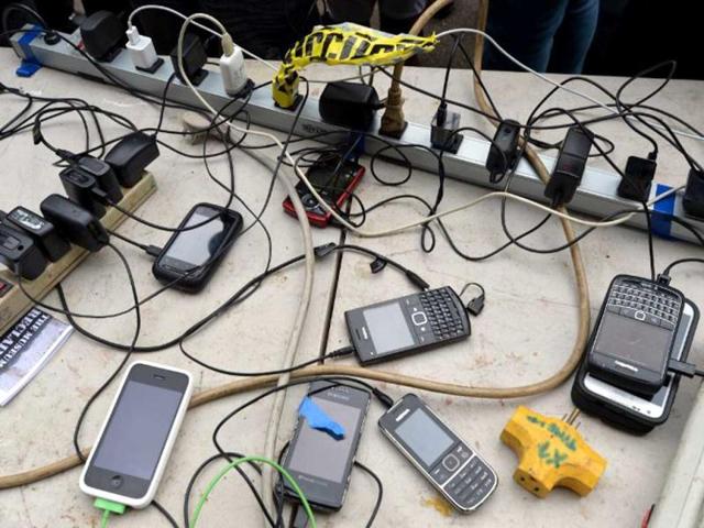 Cellphones are left to charge at a recharging point created by Ryan Nelsen and Fields Harrington, who ride a tandem bicycle to generate power in New York as the city recovers from the effects of Hurricane Sandy. (AFP Photo)