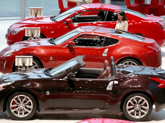 A staff passes Nissan Motor Co's vehicles displayed at company's showroom in Yokohama, south of Tokyo. REUTERS/Yuriko Nakao