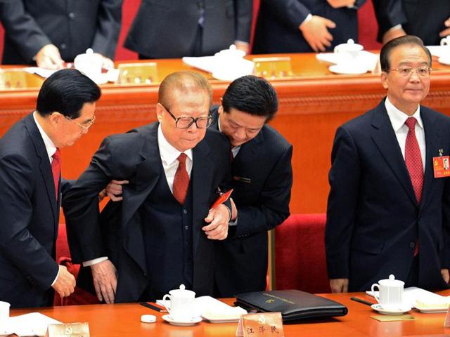 Chinese President Hu Jintao (L) assists former Chinese president Jiang Zemin to stand up as Prime Minister Wen Jiabo (L) looks on at the opening of the 18th Communist Party Congress at the Great Hall of the People in Beijing . AFP Photo/Goh Chaihin