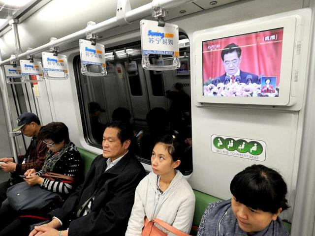 Chinese President Hu Jintao is seen speaking at the opening of the 18th Communist Party Congress on a television in a subway train in Shanghai. AFP Photo/Peter Parks