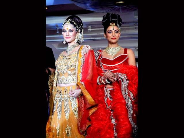 Sunny Leone and Sushmita Sen walked the ramp in designer Rohit Verma's creations at a recent event. While Sushmita looked classy and stunning in the bright red outfit, Sunny looked too gawdy and over-the-top. Take a look.
