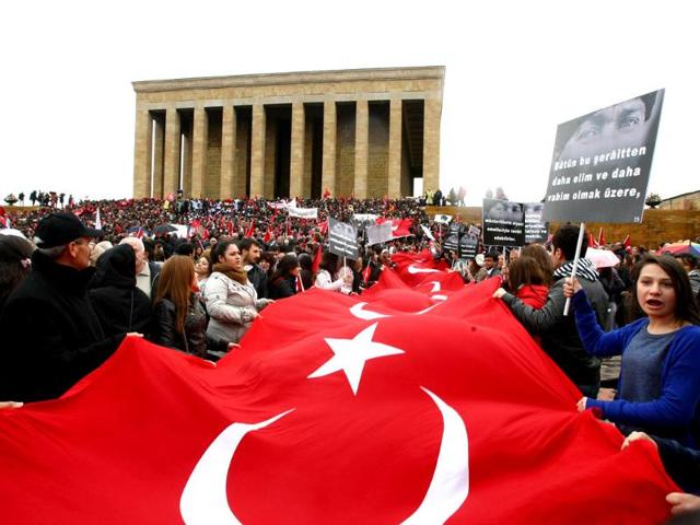 People holds the Turkish flag as they gather at the mausoleum of Turkey's founder Mustafa Kemal Ataturk during a ceremony marking the 74th anniversary of his death in Ankara. AFP/Adem Altan