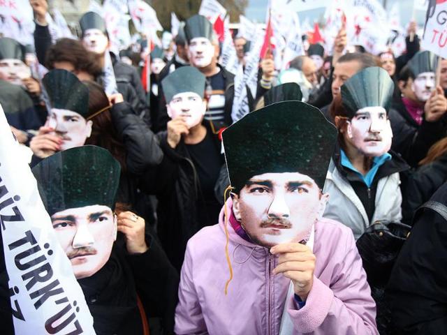 A Turkish woman wears a Mustafa Kemal Ataturk's mask during the 74th anniversary of his death, at the courtyard of the Ottoman-era Dolmabahce Palace in Istanbul. AFP/Str