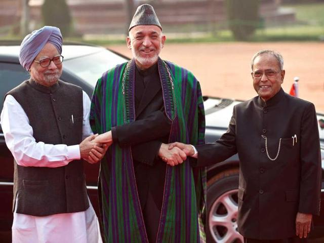 Afghan President Hamid Karzai shakes hands with President Pranab Mukherjee and Prime Minister Manmohan Singh during a ceremonial reception in New Delhi. AFP Photo