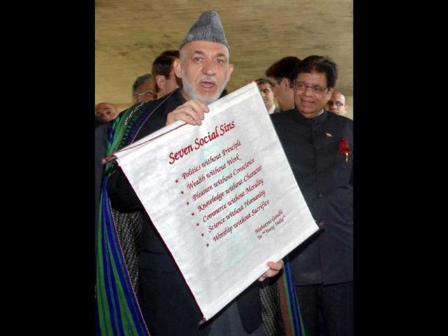 Afghanistan's President Hamid Karzai displays a scroll to the media at the Mahatma Gandhi memorial at Rajghat in New Delhi. Reuters