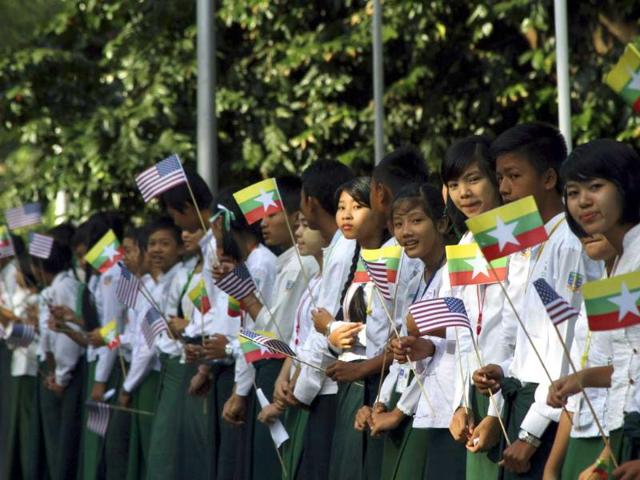 Myanmar students wave miniature Myanmar and American flags as they wait to welcome US President Barack Obama at Yangon International Airport on Monday, Nov. 19, 2012, in Yangon, Myanmar. (AP Photo/Khin Maung Win)
