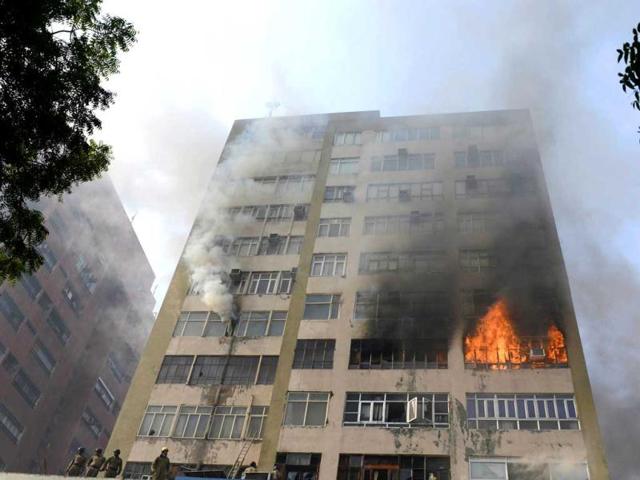 Firefighters secure the area after a fire that broke out in a fifteen story building in New Delhi. AFP