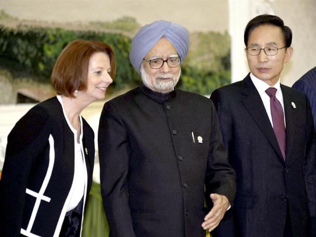 Prime Minister Manmohan Singh chats with Australia's Prime Minister Julia Gillard as South Korea's President Lee Myung-bak looks on at a group photo session at the East Asia Summit in Phnom Penh, Cambodia. PTI