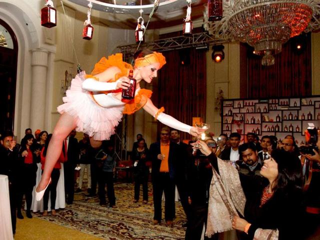 An artist serves a drink to a lady at the event that was attended by Dita Von Teese in New Delhi.