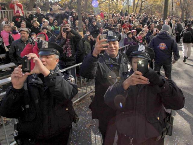 Police officers photograph Santa Claus as he rides on his sleigh down Central Park West during the 86th Macy's Thanksgiving Day Parade in New York. Reuters/Gary Hershorn