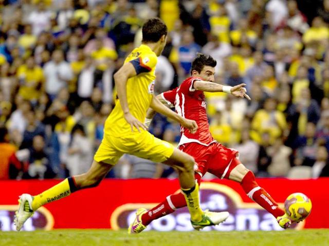 Chased by America's Diego Reyes Toluca´s Edgar Benitez scores during a Mexican soccer league match in Mexico City. AP/Christian Palma