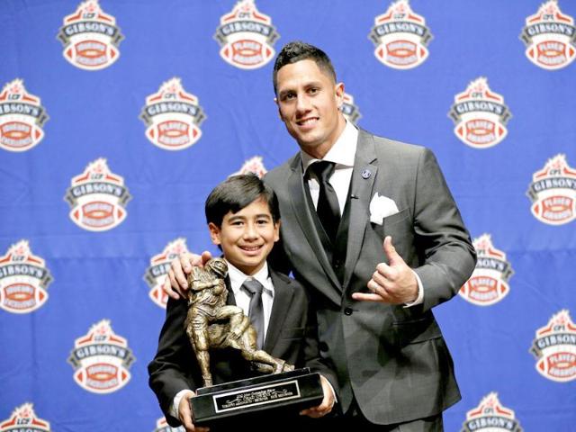Toronto Argonauts' Chad Owens and his son Chad Jr. pose with his trophy for the Most Outstanding Player award at the annual CFL player awards ahead of the 100th Grey Cup championship game in Toronto. Reuters/Todd Korol