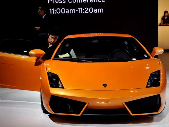 A man wipes the window of a Lamborghini car on display at the 10th China (Guangzhou) International Automobile Exhibition in Guangzhou, east China's Guangdong province. AFP