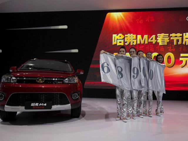 Staff members display the price of the Great Wall Motors Haval M4 mini SUV during the media preview of the 10th China International Automobile Exhibition in Guangzhou. Reuters/Tyrone Siu
