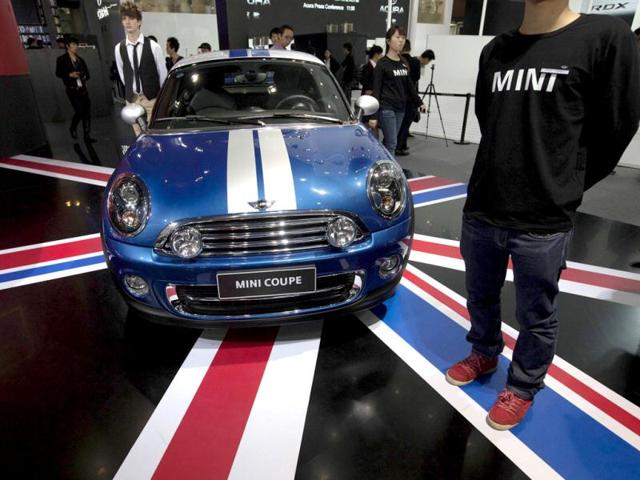 Staff stand next to a Mini Coupe during the media preview of the 10th China International Automobile Exhibition in Guangzhou. Reuters/Tyrone Siu