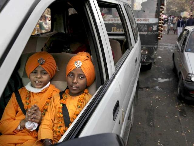 School children arrive to participate in a procession to mark the birth anniversary of the first Sikh guru, Guru Nanak, in New Delhi. AP/Manish Swarup