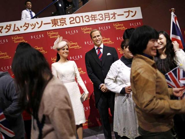 Guests holding Union Flags prepare for a photo session with wax figures of Britain's Prince William and his wife Catherine, Duchess of Cambridge, during a media briefing for the opening of the Madame Tussauds Tokyo wax museum, in Tokyo. Reuters/Issei Kato