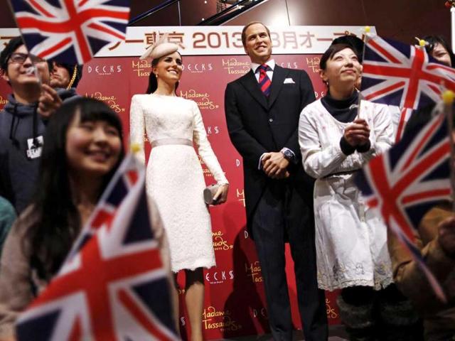 Guests wave Union Flags as they pose with wax figures of Britain's Prince William and his wife Catherine, Duchess of Cambridge, during a media briefing for the opening of the Madame Tussauds Tokyo wax museum, in Tokyo. Reuters