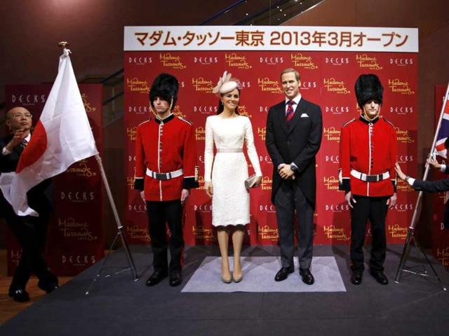 Wax figures of Britain's Prince William and his wife Catherine, Duchess of Cambridge, are prepared for a photo session next to models wearing costumes depicting the Queen's guards, during a media briefing for the opening of the Madame Tussauds Tokyo wax museum, in Tokyo. Reuters/Issei Kato