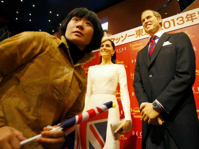 A visitor walks by wax figures of Britain's Prince William and his wife Kate, the Duchess of Cambridge in Tokyo. AP Photo/Junji Kurokawa
