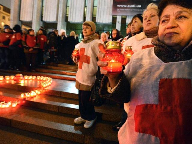 Activist of public organizations and HIV infected people hold candles as they rally in front of a Red Ribbon set with candles in the center of the Ukrainian capital of Kiev. AFP/Sergei Supinsky