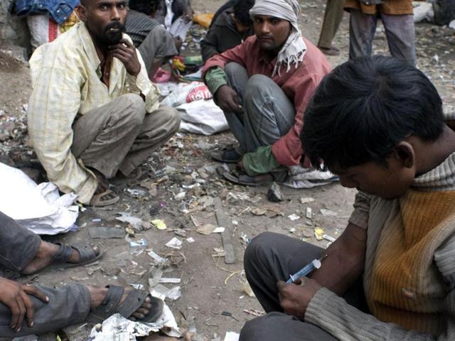 An addict injects drugs in the old sector of New Delhi. AFP/Anna Zieminiski